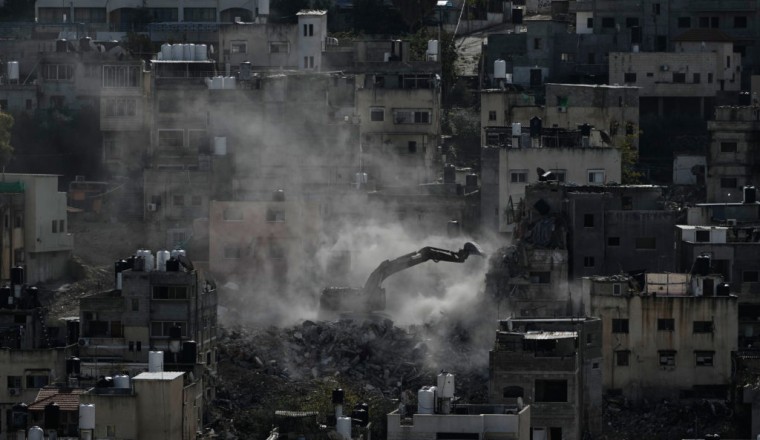 Palestinians watch as Israeli bulldozers claw down their West Bank homes